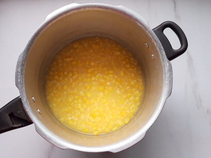 Uma panela de pressão contendo milho cozido.