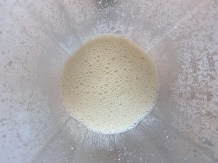 Um liquidificador com a mistura do soro do leite, manteiga e queijo talhado.