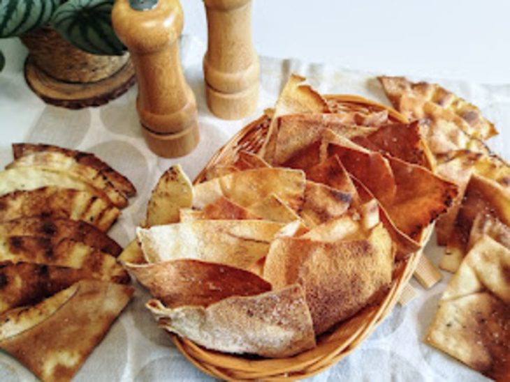 Uma cesta contendo nachos com pão árabe.