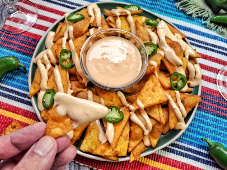 Prato com tortilhas de milho servidas com molho de queijo.