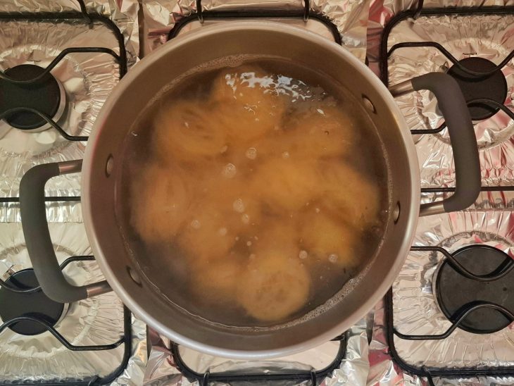 Uma panela com água cozinhando os macarrões cabelo de anjo.