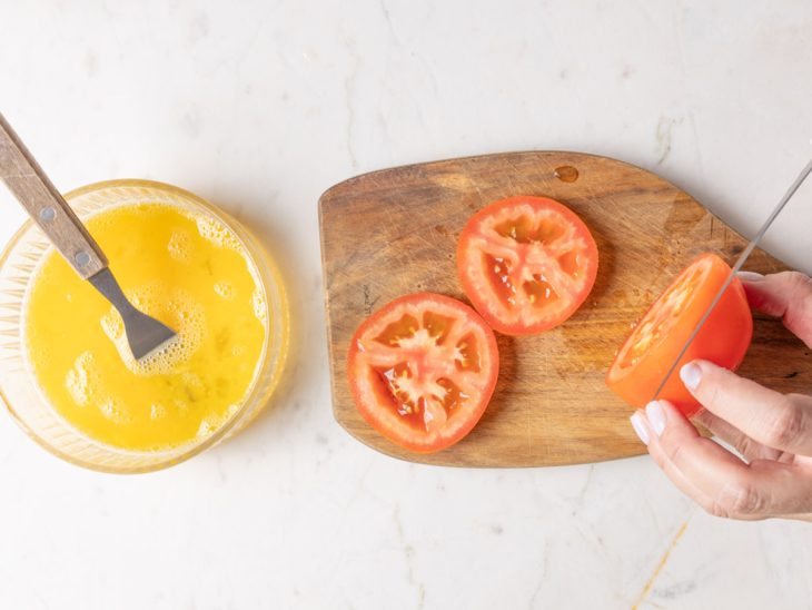 tomate cortado em rodelas sobre uma tábua