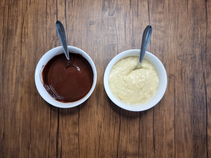 cocada cremosa e ganache separadas em potinhos e com as colheres posicionadas para a montagem do ovo de páscoa