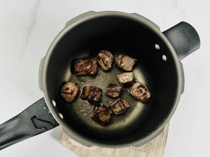 Pedaços de carne selados na panela.