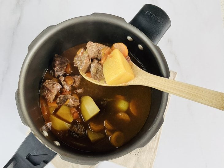 Carnes e legumes cozidos e macios na panela.