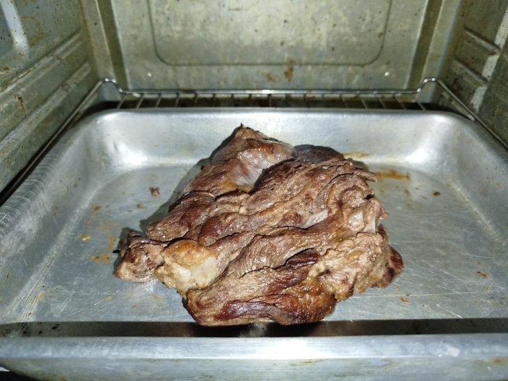 Uma forma com a paleta bovina assando no forno.