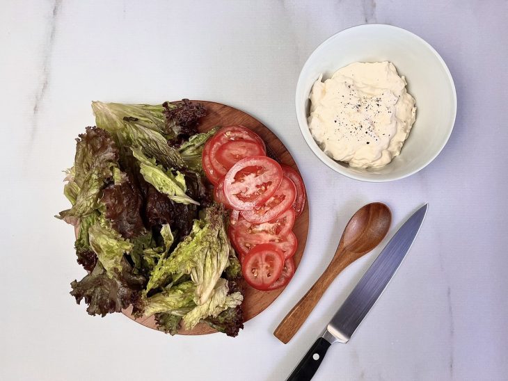 Salada e maionese em pratos sobre uma bancada