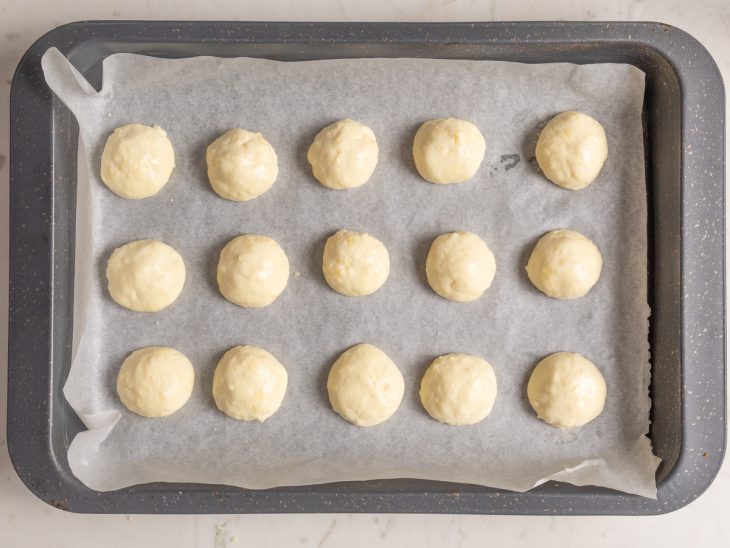 Forma com papel-manteiga com bolinhas de massa do pão de queijo de kefir.