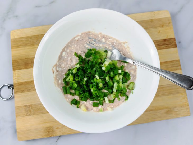 Uma tigela com iogurte, atum, suco de limão, sal e cebolinha.