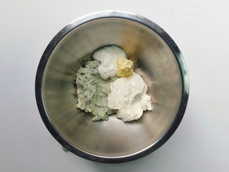 Um recipiente contendo gorgonzola amassado, manteiga, creme de leite e cream cheese.