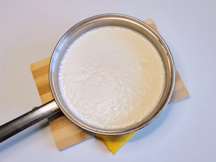 Uma panela contendo a mistura de amido de milho, leite condensado, creme de leite e leite.