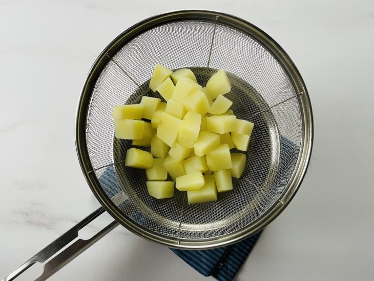 Um recipiente contendo batatas cozidas.