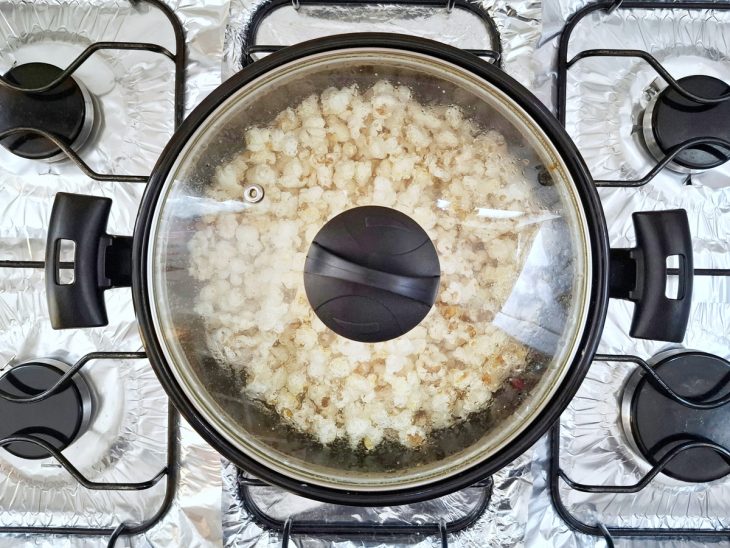 Panela tampada com pipoca estourada.