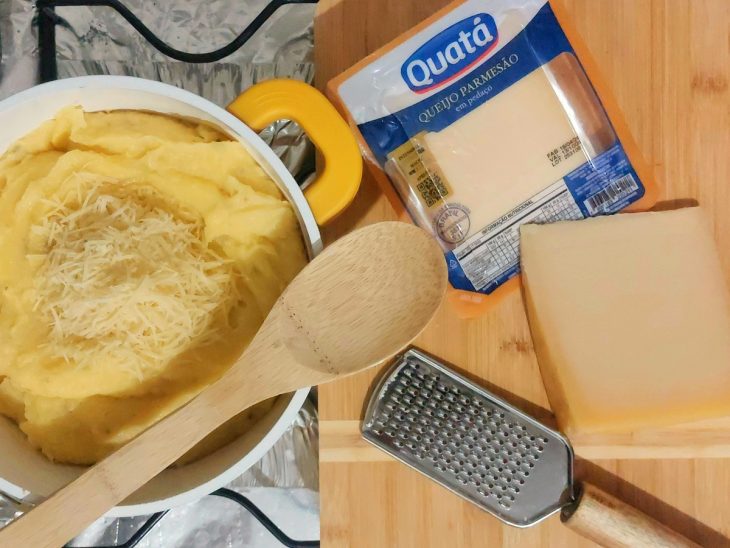 Uma panela com polenta e queijo.