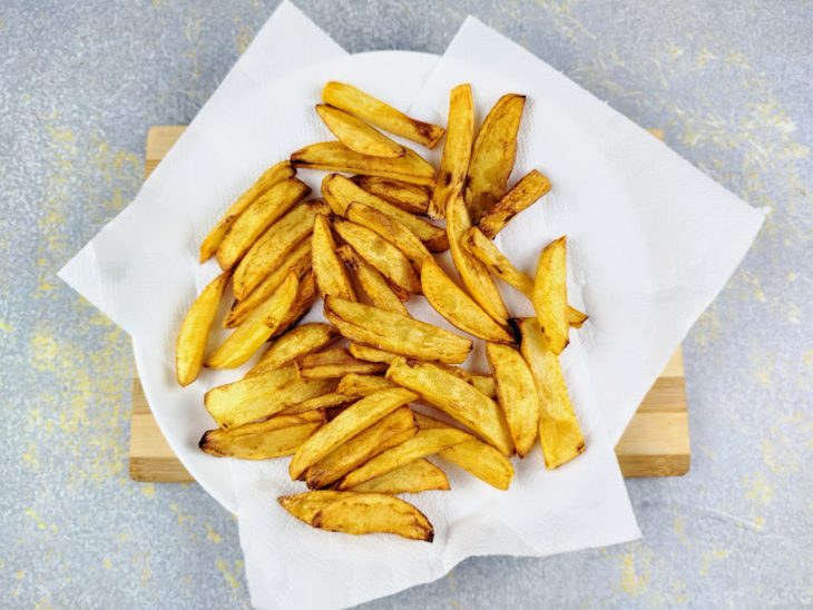 Batatas fritas em um recipiente forrado com papel-toalha.