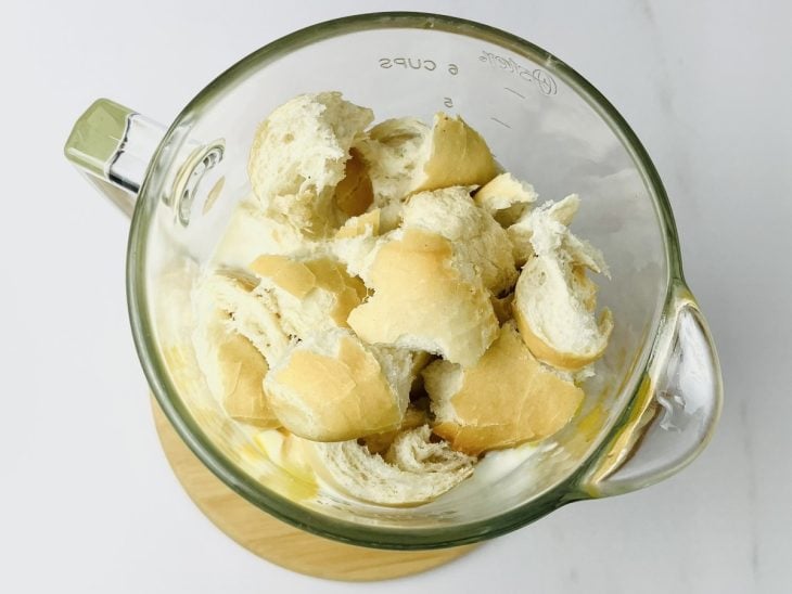 Ovos, leite condensado, creme de leite, leite e pães no liquidificador para bater.