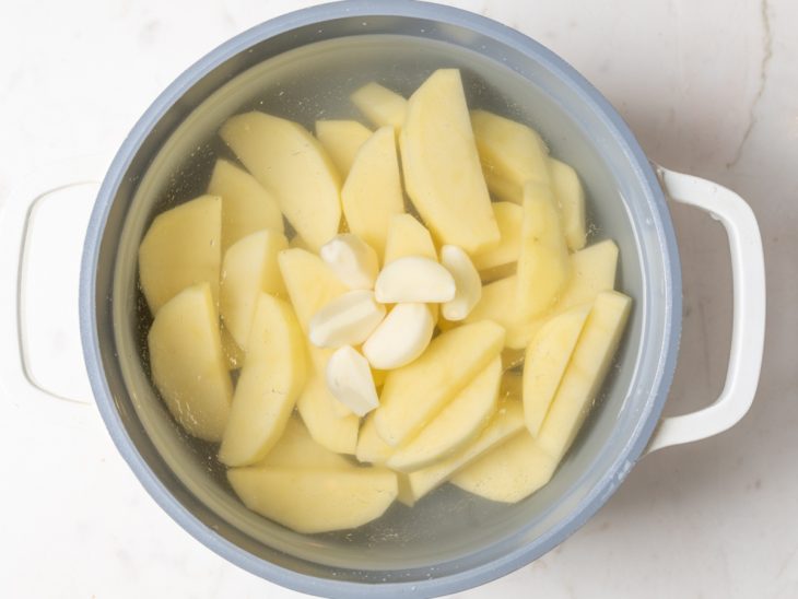 Uma panela com as batatas e alho a cozinhar.