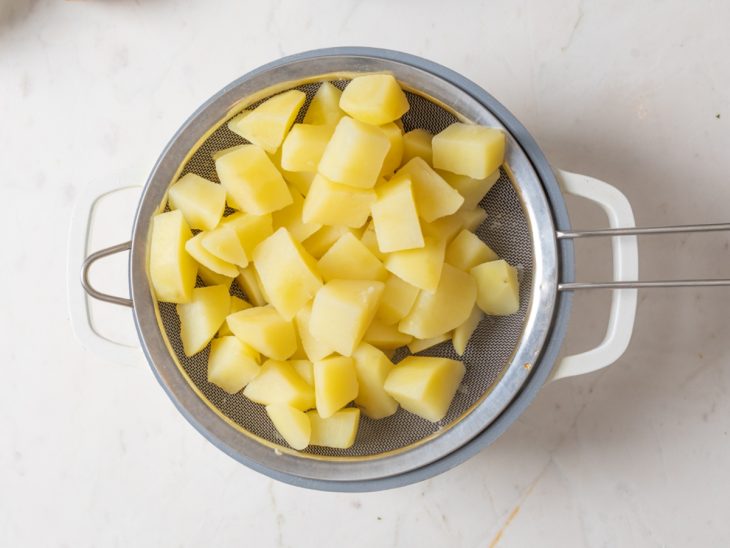 Batatas cozidas em uma peneira.