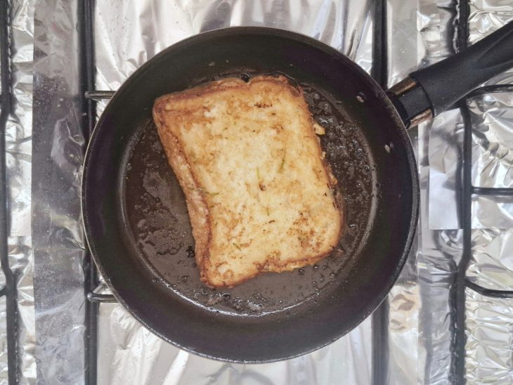 Fatia de pão na frigideira com manteiga.