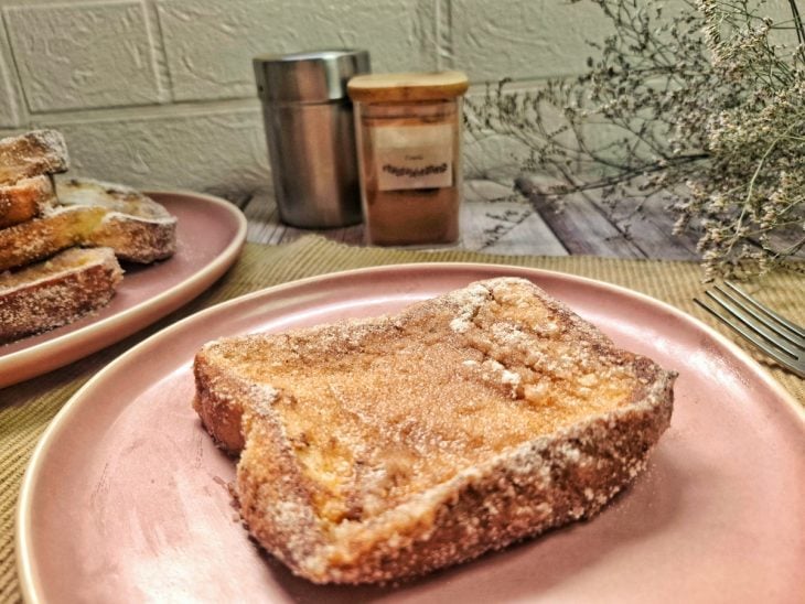 Fatia de rabanada fácil e rápida, finalizada com açúcar e canela, pronta para consumo.