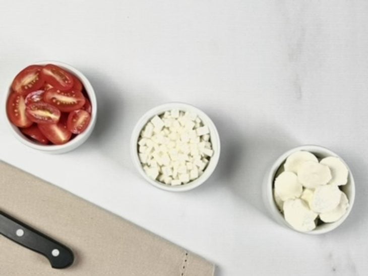 três recipientes, em cada um: cebola picada, tomatinho-cereja picado e bolinhas de mussarela