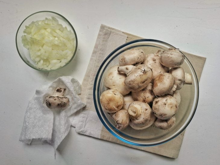 Cogumelos e cebolas picadas em uma vasilha.