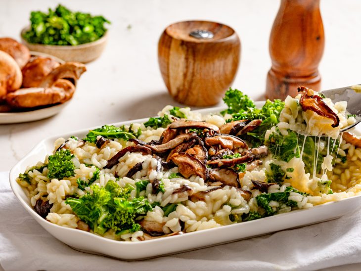 Uma travessa contendo risoto de cogumelos e kale.