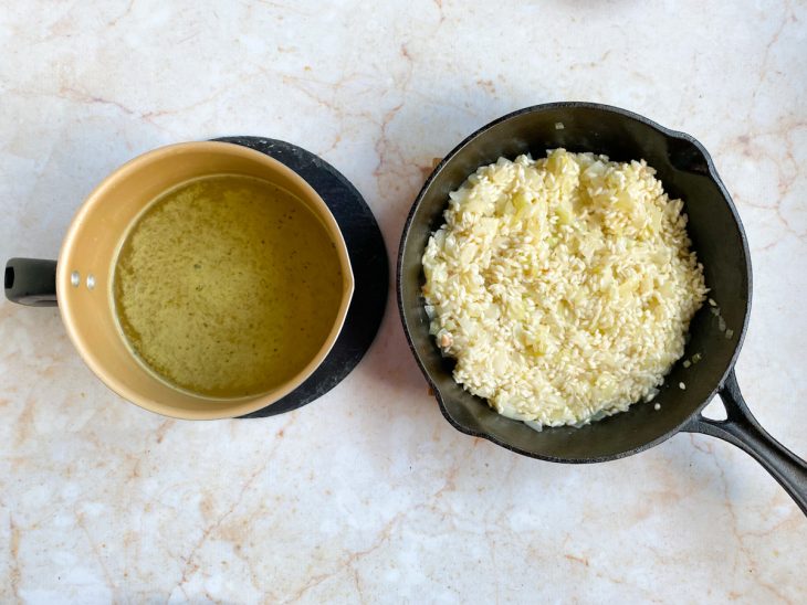 Frigideira com arroz cozinhando e panela com caldo de legumes.