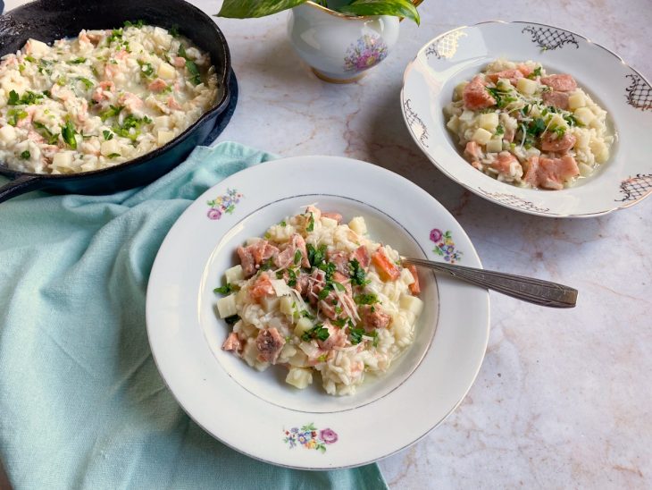 Pratos contendo risoto de palmito e salmão.