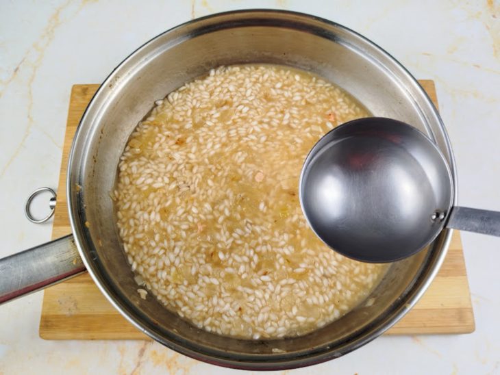 Uma panela com o arroz, temperos e água.