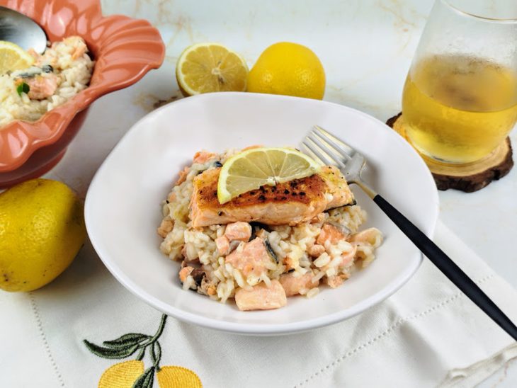 Um prato contendo risoto de salmão com limão-siciliano.