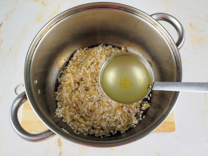 Concha de caldo de legumes despejada na panela.