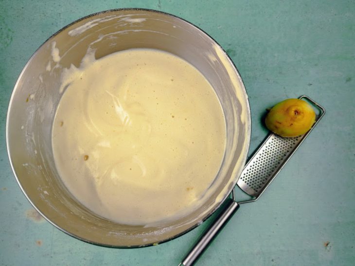 Uma tigela com a mistura de gemas, claras batidas, açúcar e raspas de limão.