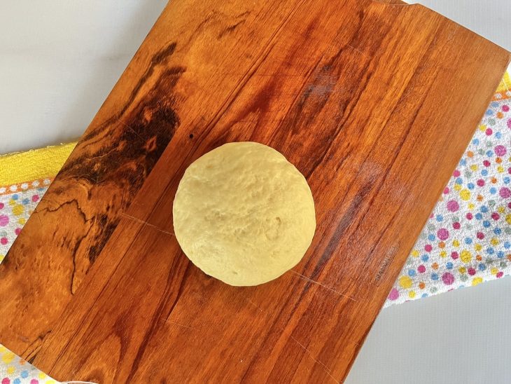 Uma bolinha da massa de rosquinha sobre a tábua.