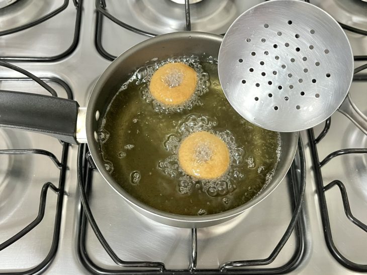 Rosquinhas fritando no óleo quente.