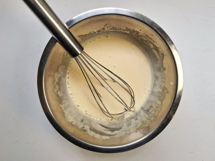 Uma tigela com a mistura dos ingredientes do creme branco.