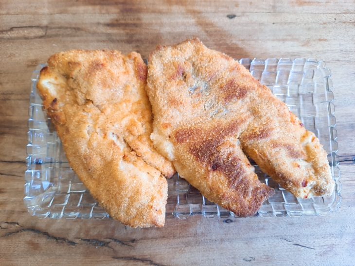 Peixe Saint Peter empanado na air fryer e recém tirado da fritadeira. A aparência é crocante e a casquinha está sequinha e dourada.