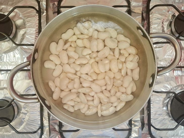 Panela com fava coberta por água.