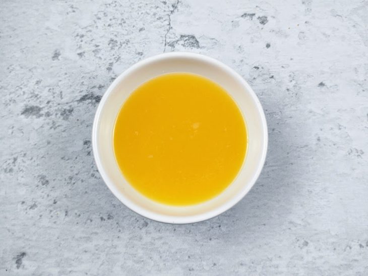 Uma tigela com suco de laranja.