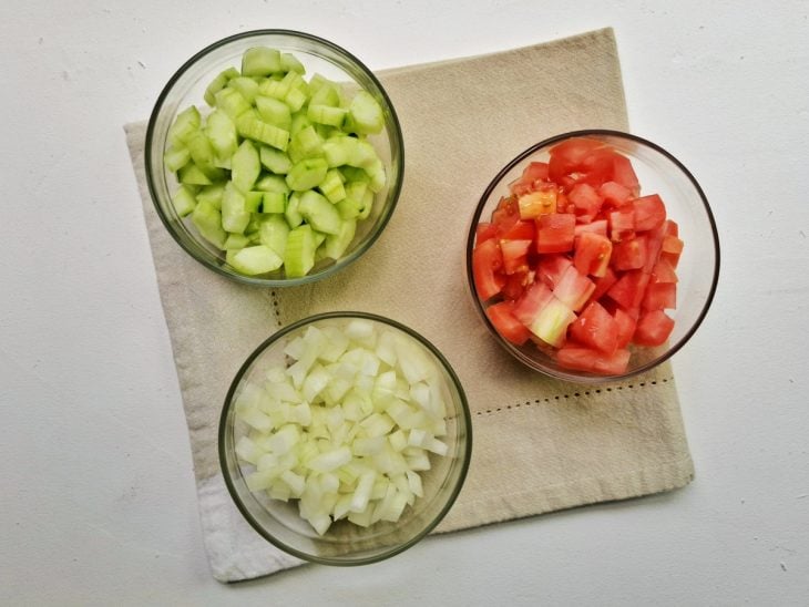 três recipientes, em cada um, tomate picado, cebola picada e vagem picada