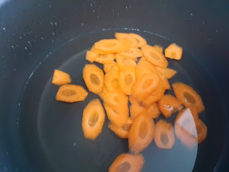 fatias de cenoura em uma panela, cobertas com água, para cozinhar