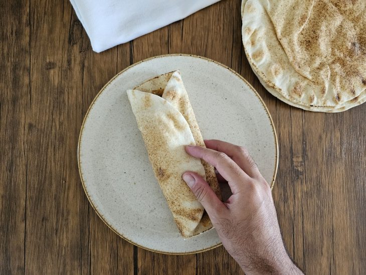 Um pão sírio fechado com o recheio do shawarma.