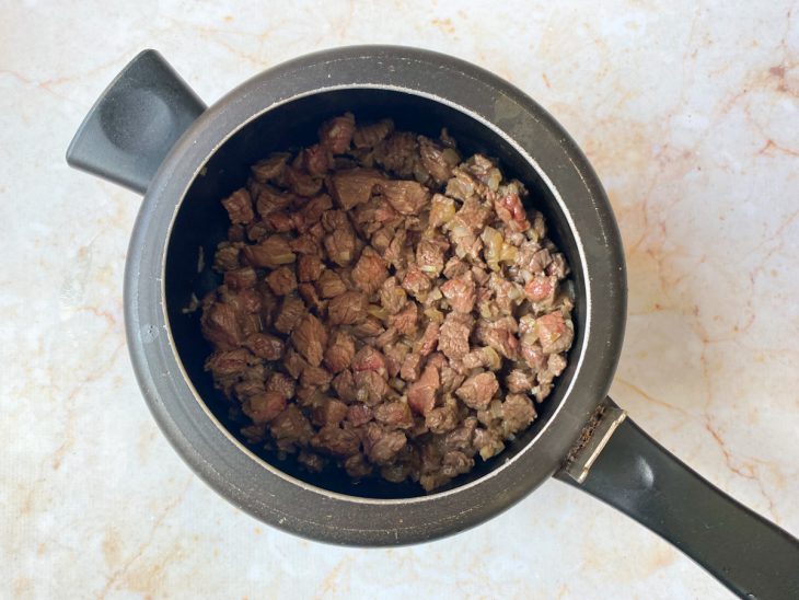 Cubos de carne adicionados a panela.