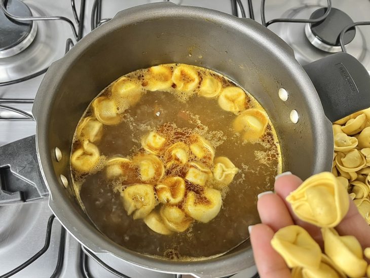 Uma panela contendo capeletti de carne sendo cozidos.