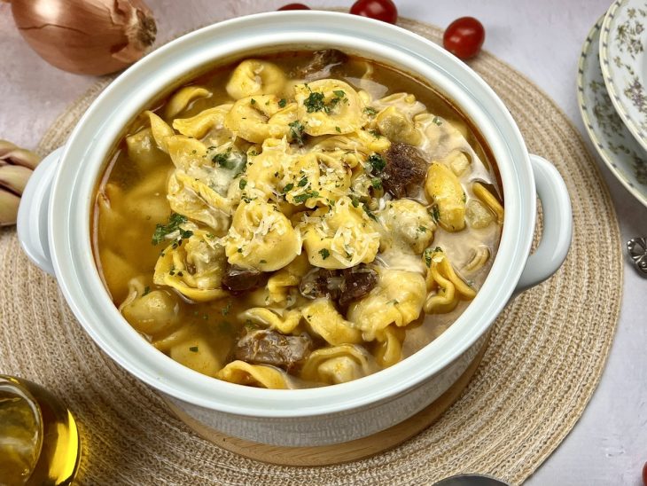 Uma panela contendo sopa de capeletti de carne.