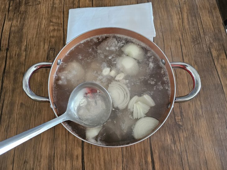 Uma panela com as carnes cozinhando na água.