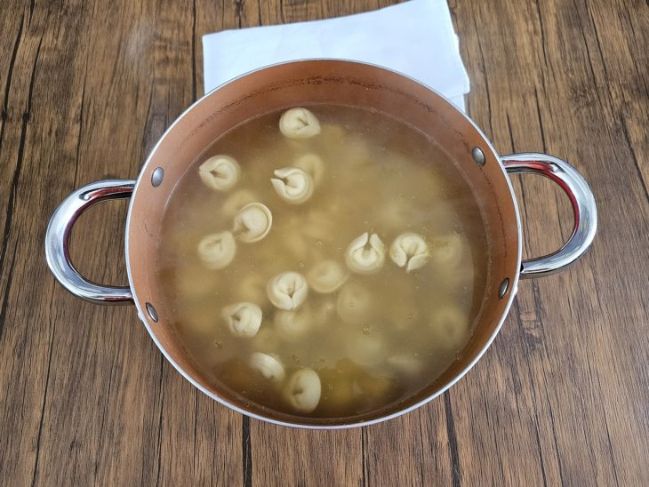 Uma panela com o macarrão cozinhando.