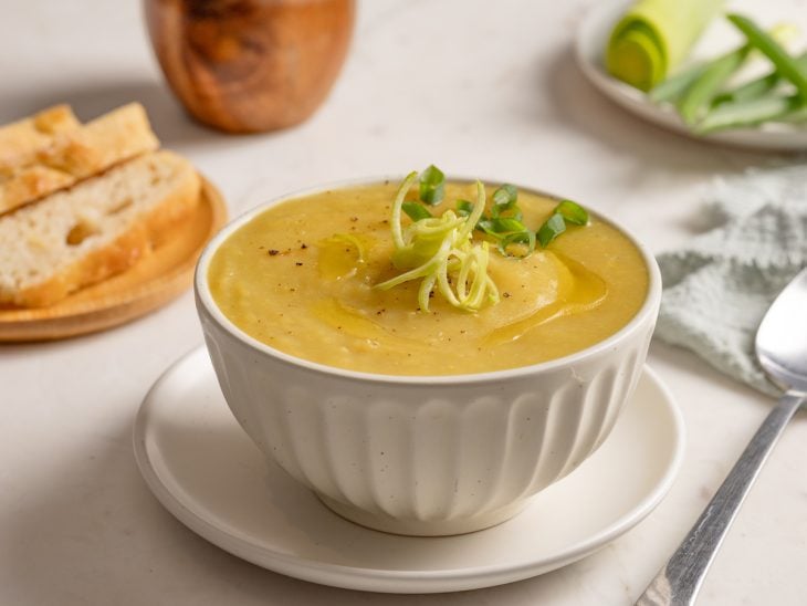 Sopa de legumes com alho-poró finalizada com cebolinha, pronta para consumo.