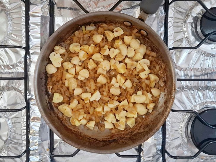 Cebola, alho e cogumelos na frigideira utilizada para a carne.