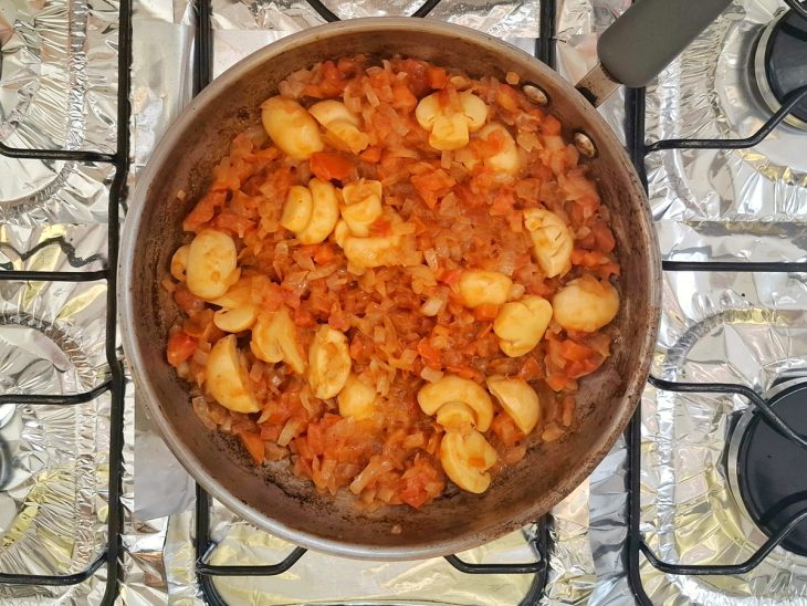 Tomate picado, molho inglês e champignons adicionados a frigideira com cebola.